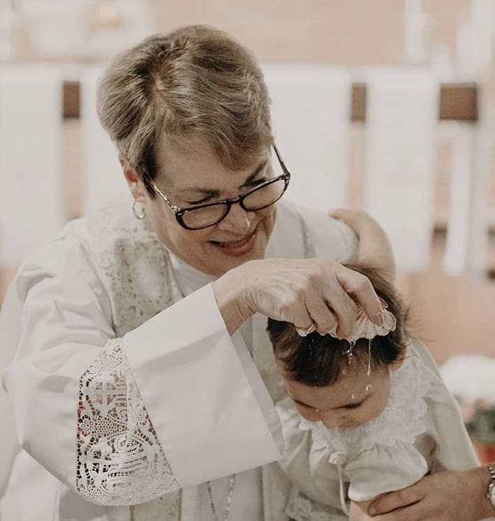 A woman is combing the hair of a baby.