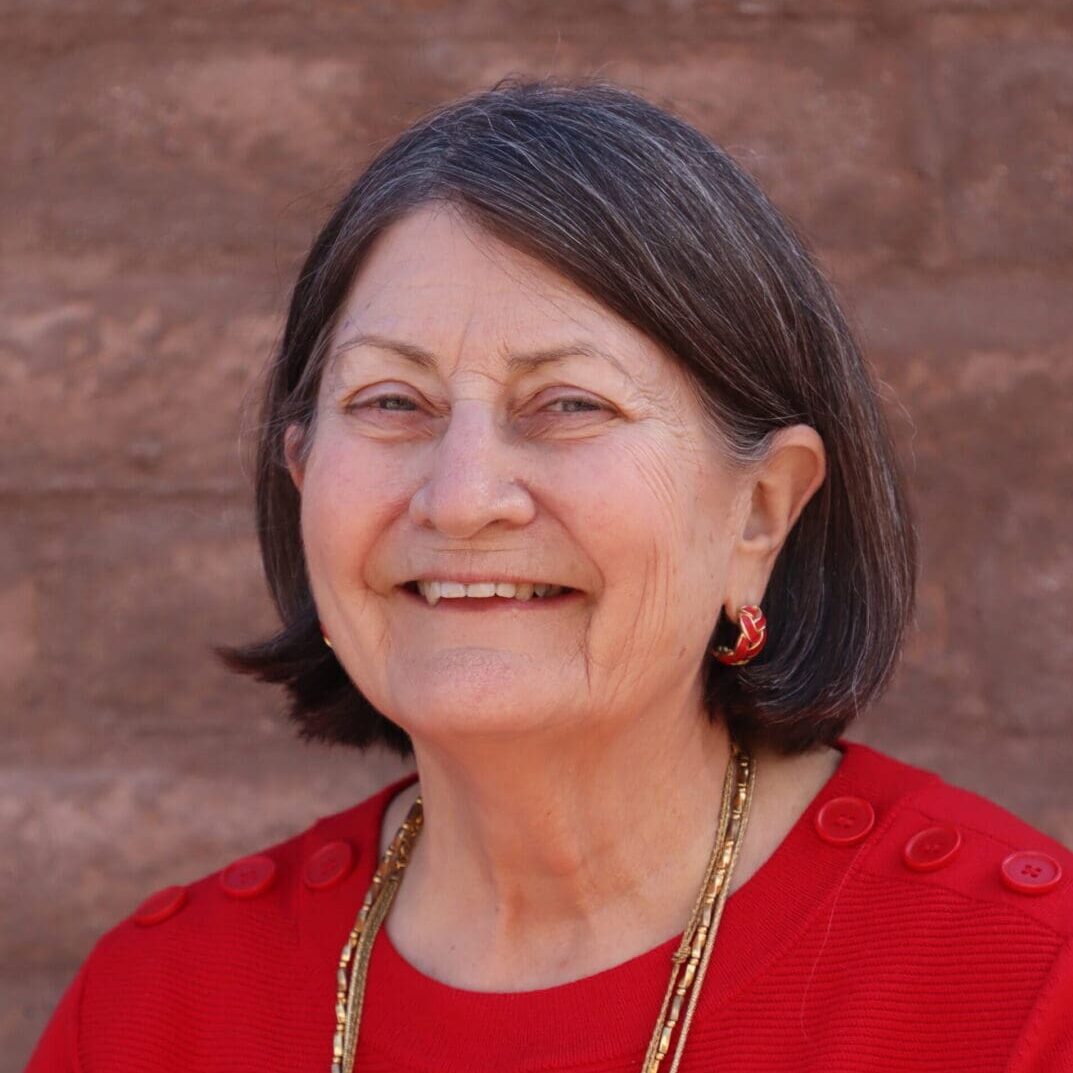 A woman in red shirt smiling for the camera.