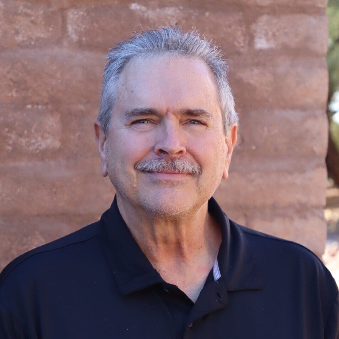 A man with grey hair and a black shirt.